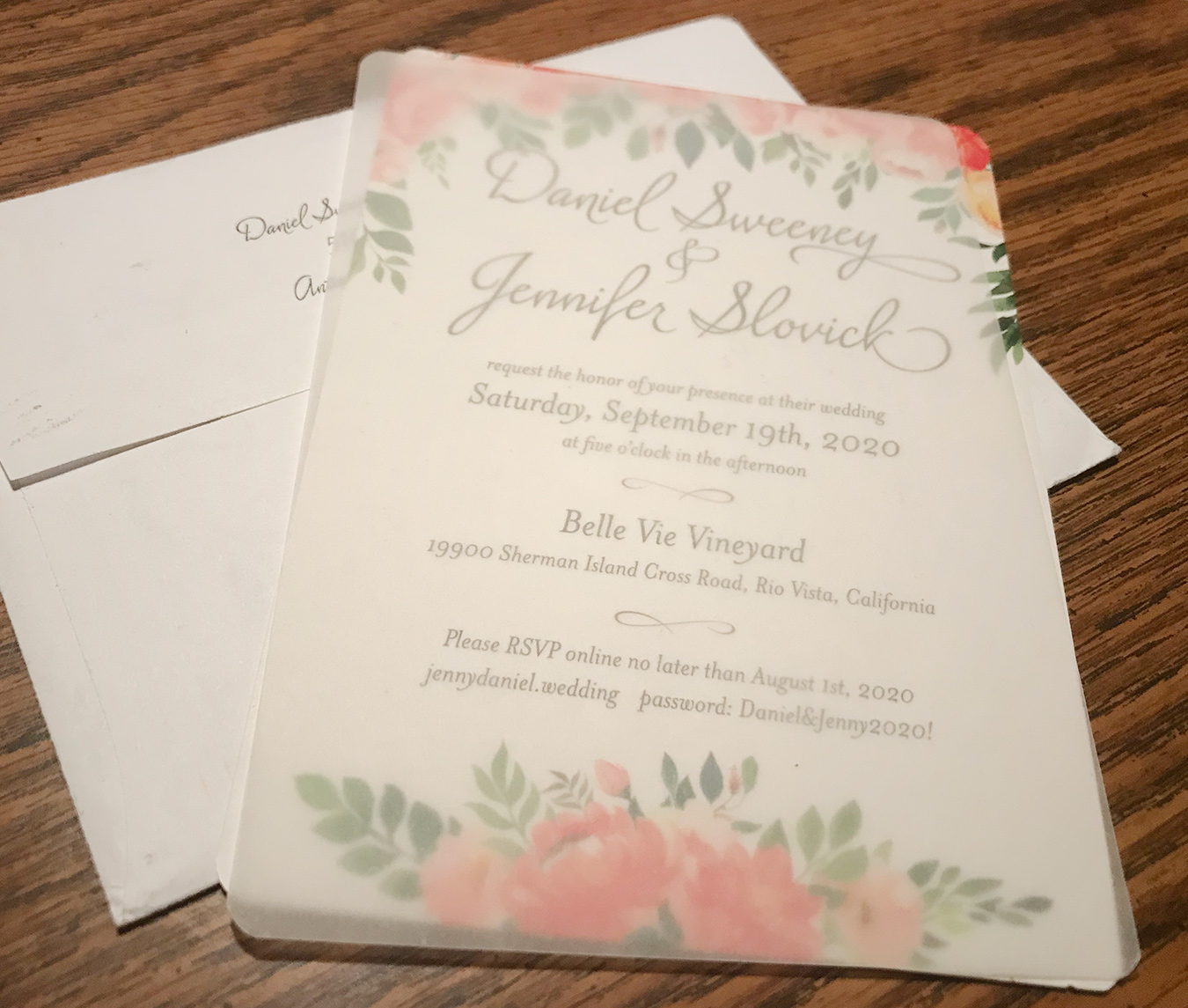 wedding invitation and envelope on a brown table